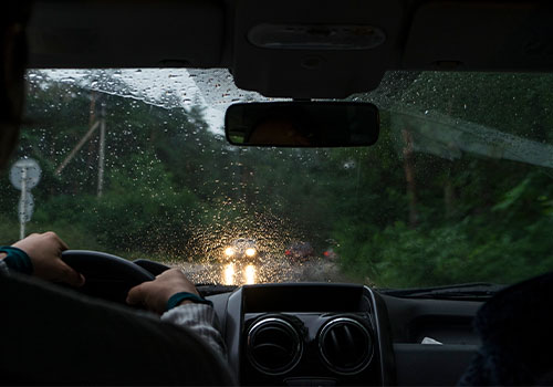 Pessoa a conduzir um carro em época de chuva