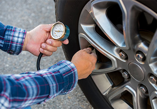 Pessoa a medir a pressão dos pneus