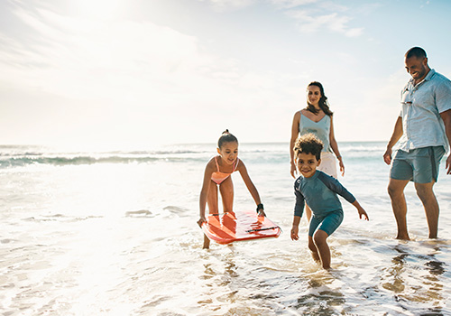 família a divertir-se na praia