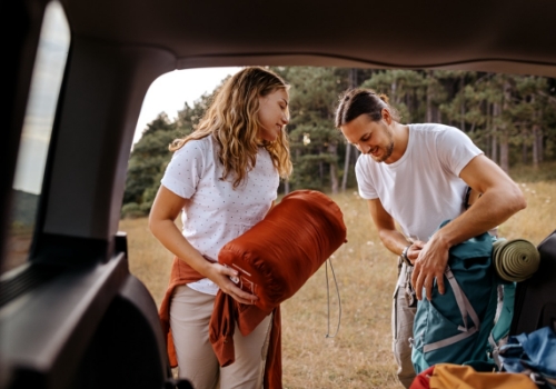 young couple preparing gear for hike