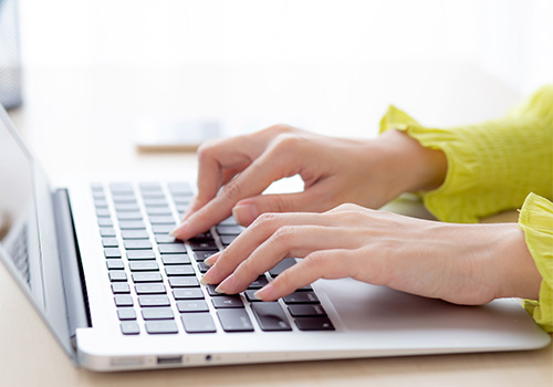 woman typing on computer keyboard