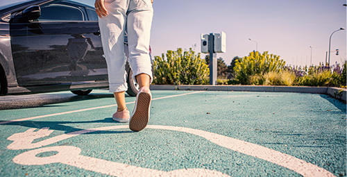 woman walking towards electric car