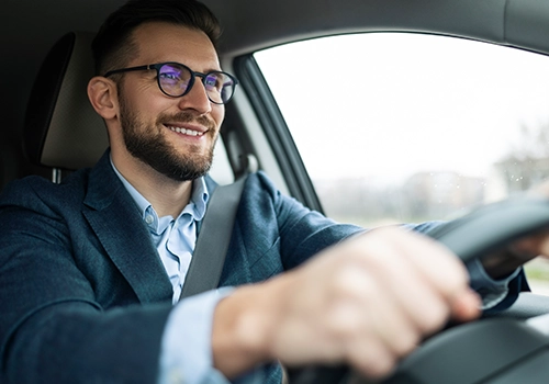Smiling businessman driving his car