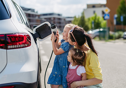 mãe e filha a carregar o carro elétrico