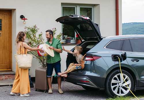 Family unloading luggage from car.