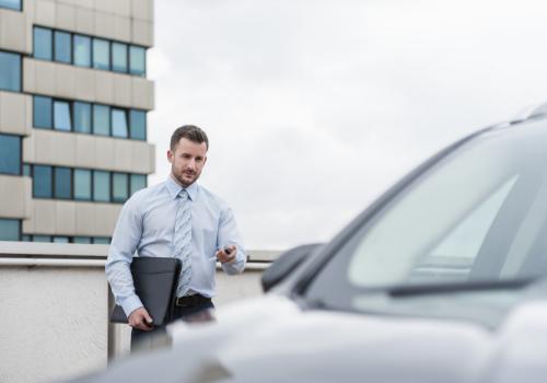 Businessman opening car on parking lot