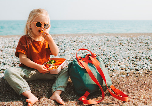 child girl eating vegetables outdoor