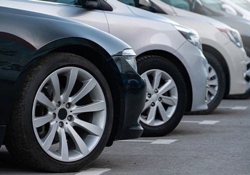 Pormenor dos pneus de uma frita de carros de empresa em fila.