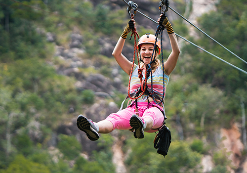 Young joyful woman rappelling