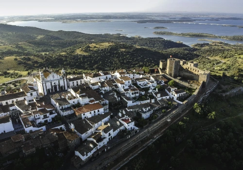 A panoramic view of the village of Monsaraz, overlooking the Alqueva Dam, in Alentejo, where you can enjoy a wine tour experience.