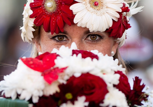 Female performer wearing a traditional floral costume during the Madeira Flower Festival parade.
