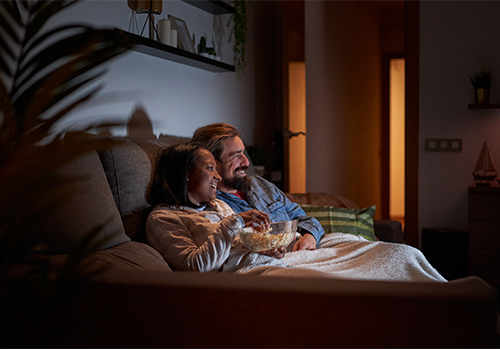 Casal a assistir em casa aos filmes gravados em Portugal.