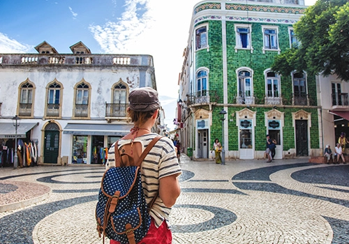 Turista a passear numa cidade do Algarve durante a Primavera em Portugal