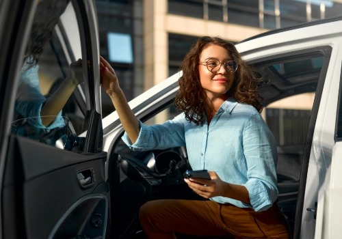 Businesswoman sitting in the driver’s seat of a hire car for a business journey