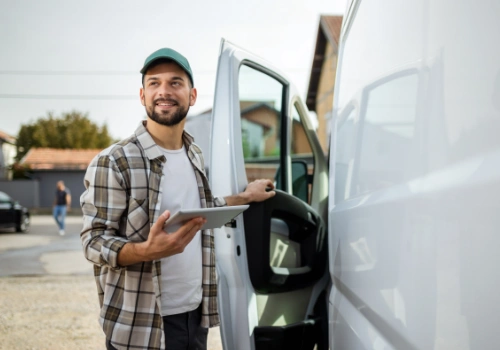 Worker checking deliveries next to a hired van