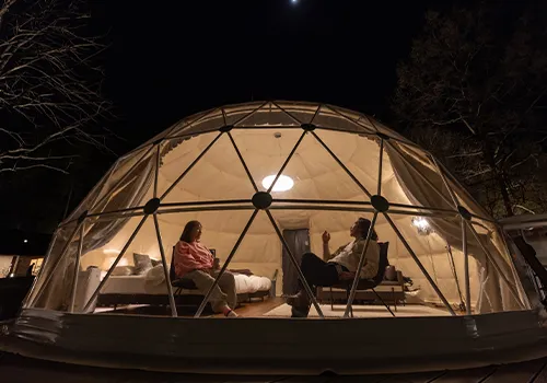 Couple relaxing in a glamping tent in the mountains