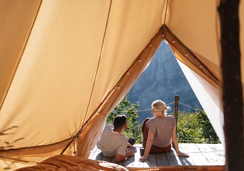 Casal a relaxar numa tenda de glamping montanha
