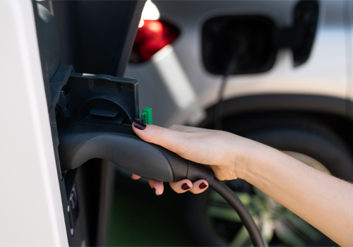 mão a segurar plug-in carro elétrico