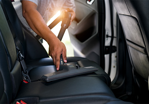 Man vacuuming car seats