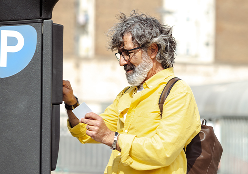 Man paying for parking at a parking meter.