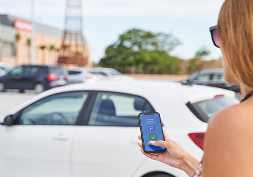 Woman paying for parking using her mobile phone.