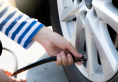 Woman checking the tyre pressure