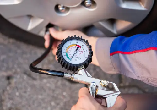 Person checking the tyre pressure