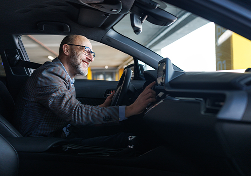 Happy businessman inside his leased corporate car
