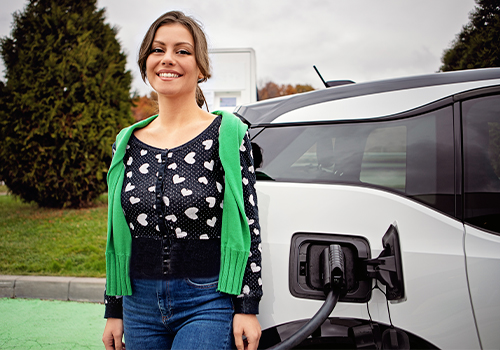 mulher a carregar o carro elétrico