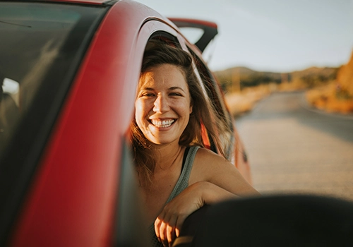 woman smiling out of the window of a hired electric car