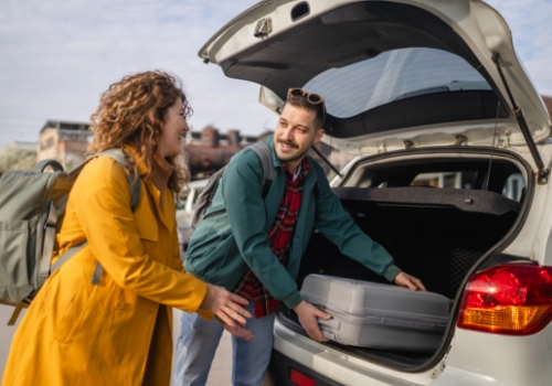 Group of friends with luggage in the car