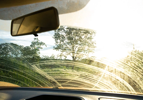Vista do interior de carro com para-brisas coberto de pó após etapa em estrada de terra.