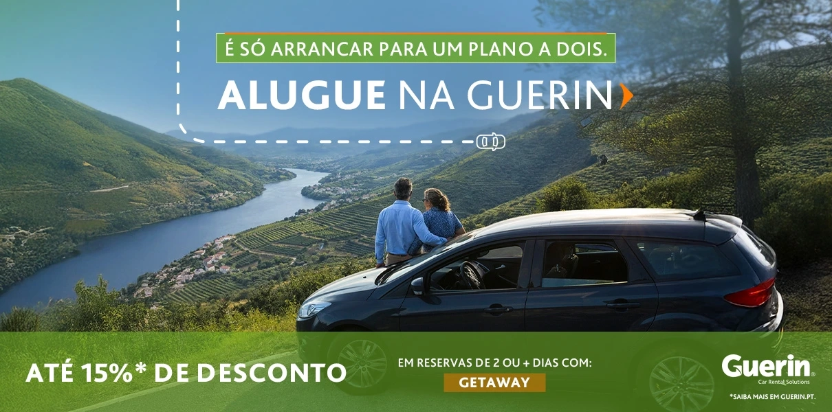 Casal sentado junto a um carro num miradouro com vista para um vale e rio, com texto promocional da Guerin: &ldquo;Alugue na Guerin&rdquo;, at&eacute; 15% de desconto em reservas de 2+ dias com o c&oacute;digo GETAWAY