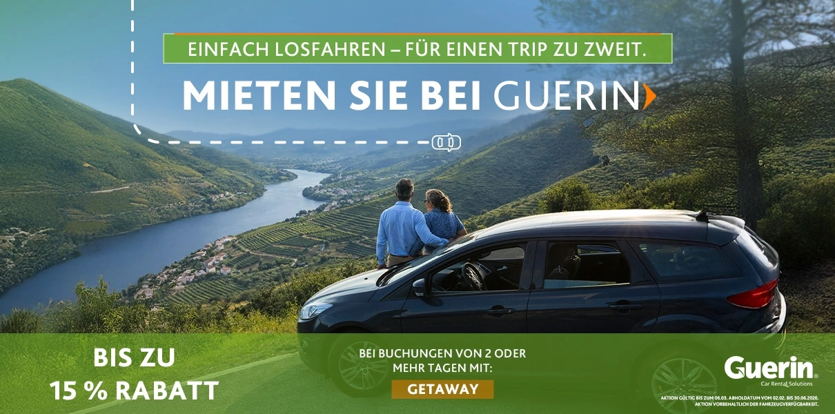 Paar sitzt neben einem Auto auf einem Aussichtspunkt mit Blick auf ein Tal und einen Fluss, mit Werbetext von Guerin: &bdquo;Mieten Sie bei Guerin&rdquo;, bis zu 15 % Rabatt auf Buchungen von 2+ Tagen mit dem Code GETAWAY