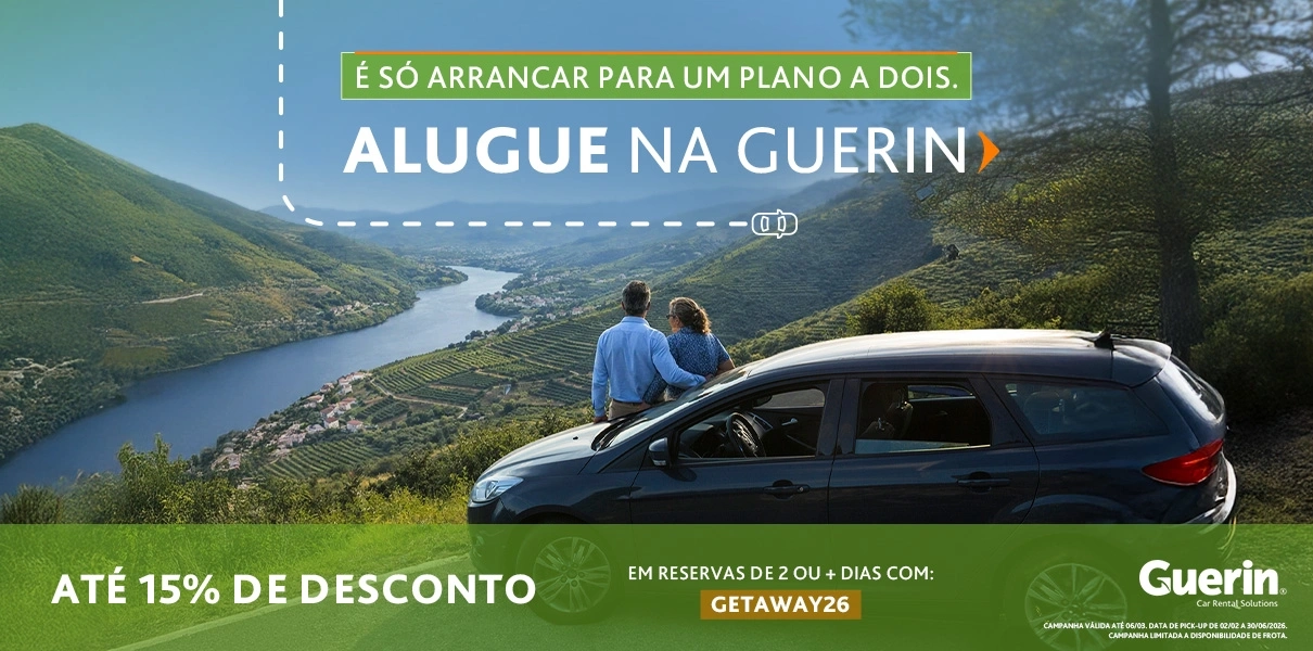 Casal sentado junto a um carro num miradouro com vista para um vale e rio, com texto promocional da Guerin: &ldquo;Alugue na Guerin&rdquo;, at&eacute; 15% de desconto em reservas de 2+ dias com o c&oacute;digo GETAWAY